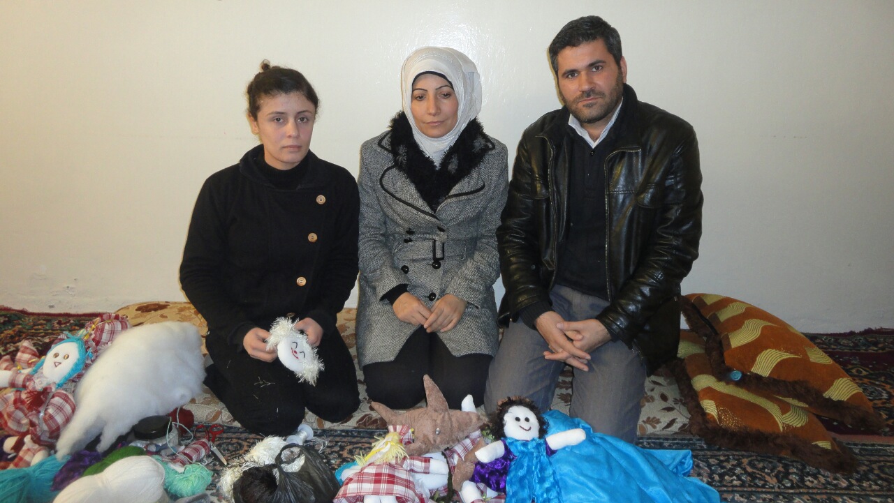 Hayat and family kneeling behind handmade toys