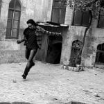 Man kicking an orange in a courtyard