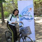 Girl in headscarf on bicycle