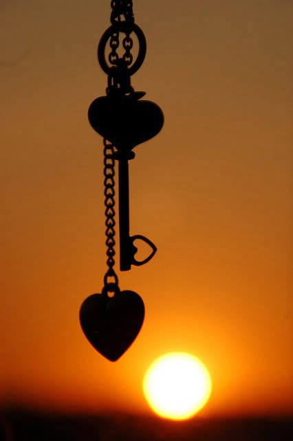 Heart and key silhouetted against sunset