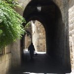 Person walks through an arch in an Aleppo street