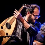 Orwa Saleh holding an oud