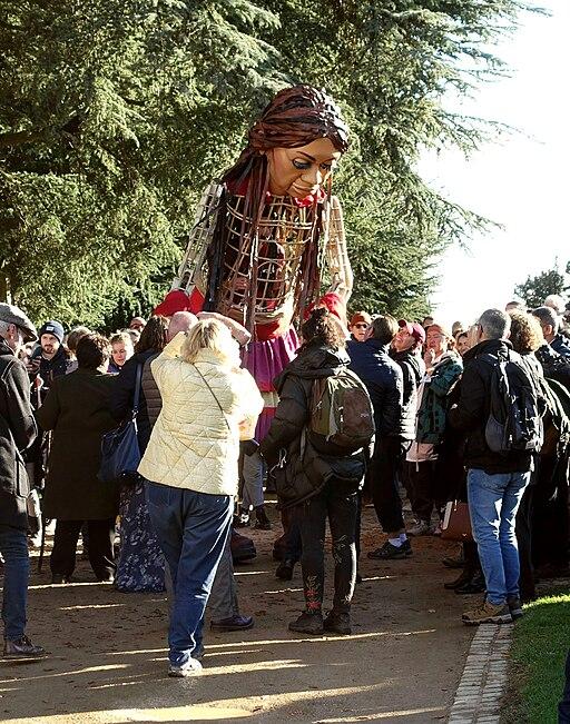 Little Amal surrounded by people.